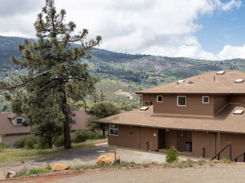 Juanico Lodge exterior with tree and hills