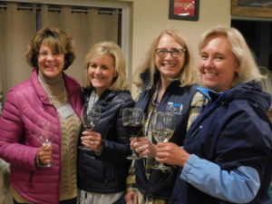 Four women holding wine glasses in the Dining Hall